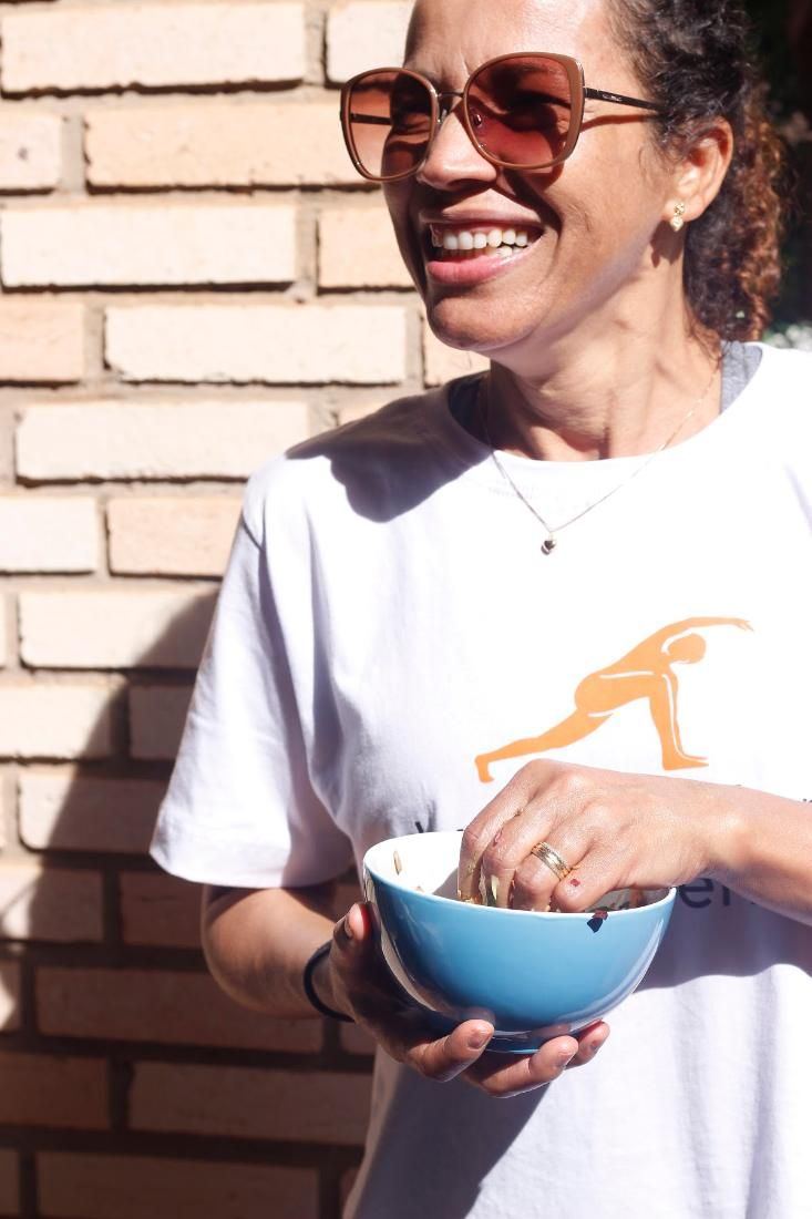 Aluna sorrindo com sua tigela de salada