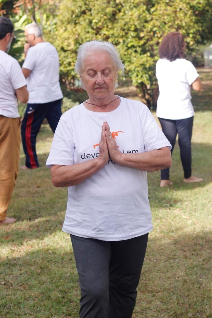 Aluna de mãos postas no jardim